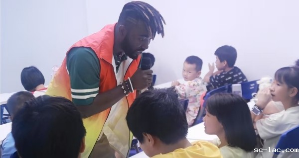 实践团留学生志愿者用外语与儿童对话。郑佳欣摄
